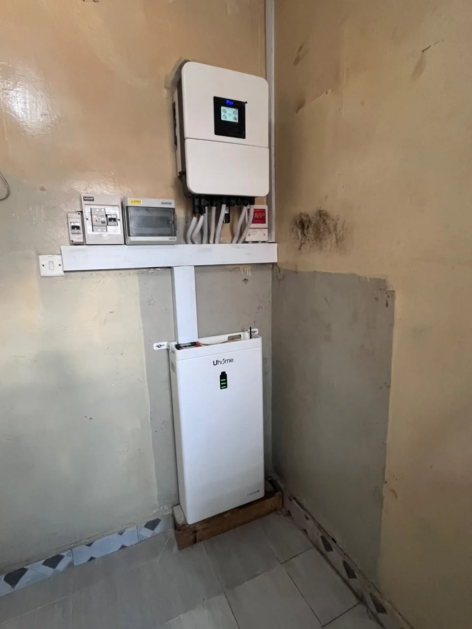 Deye hybrid inverter with floor-mounted Uhome lithium battery and conduit wiring in Bondeni