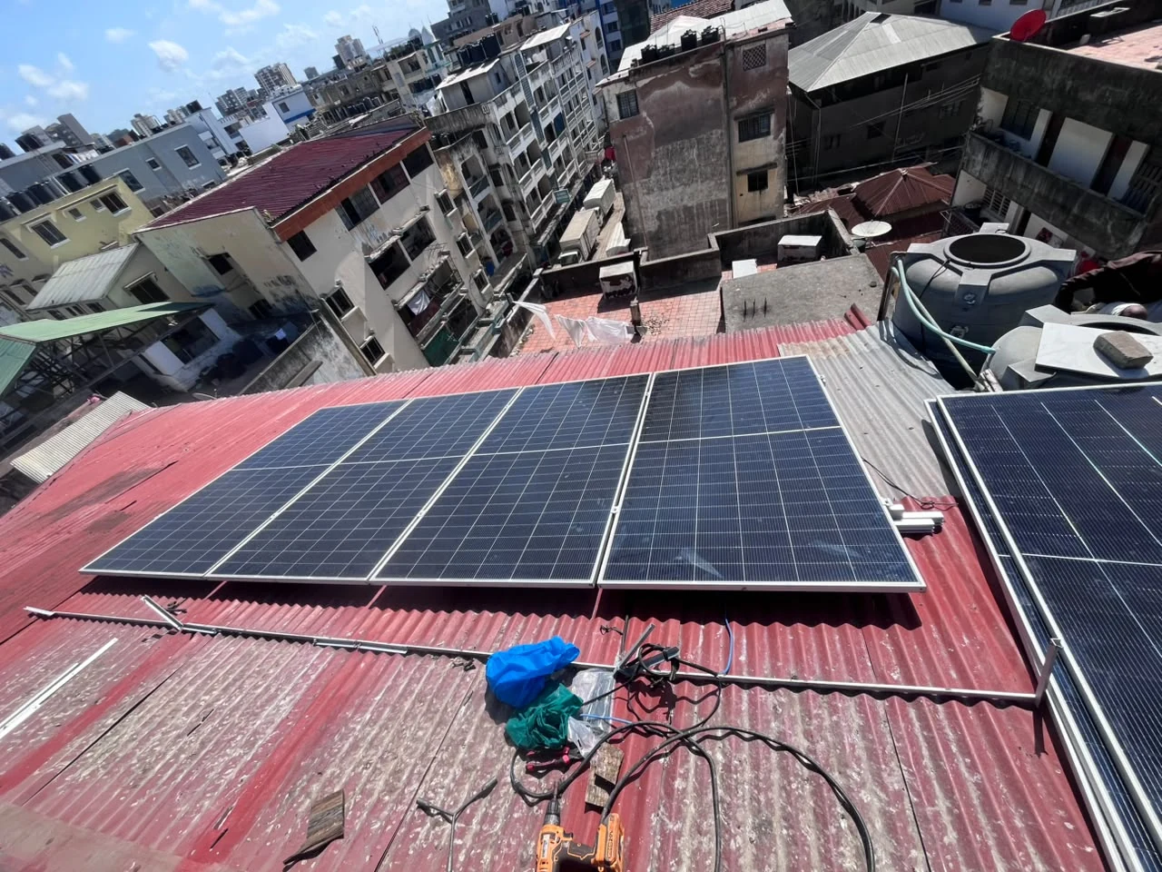 Completed rooftop solar array with Mombasa Island skyline — Bondeni project
