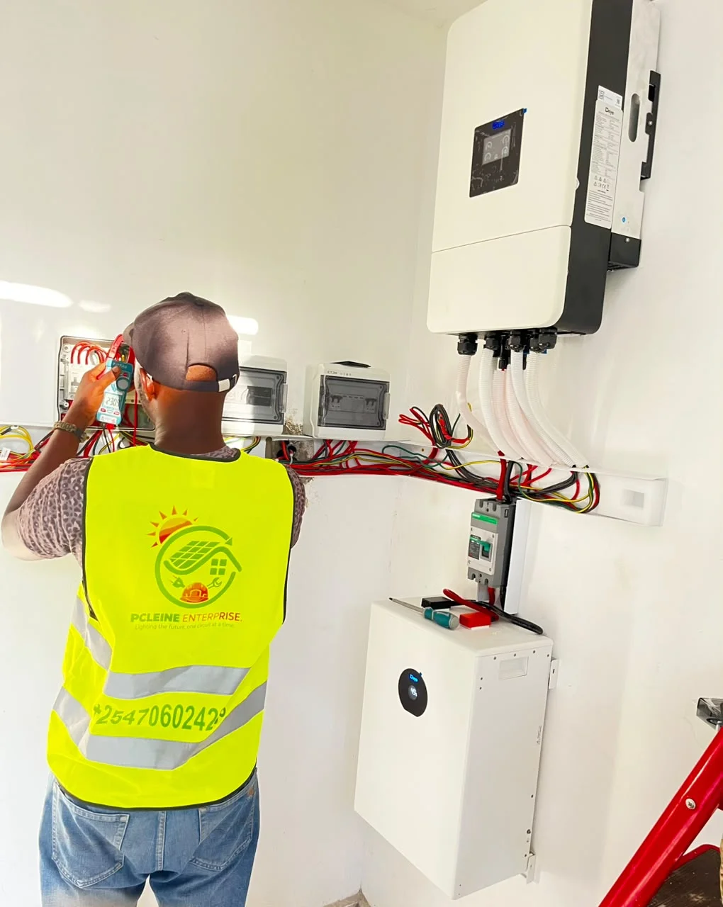 PCLEINE certified technician measuring line voltage with digital clamp meter during commissioning in Nyali