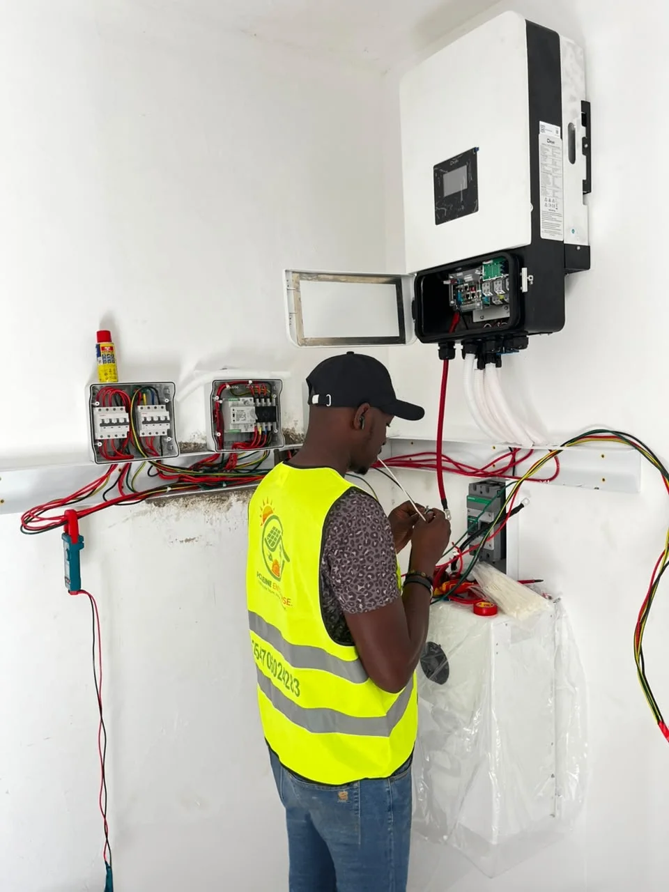 Certified technician terminating control and battery wiring into Deye hybrid inverter